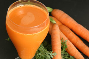 Glas Karottensaft und Karotten