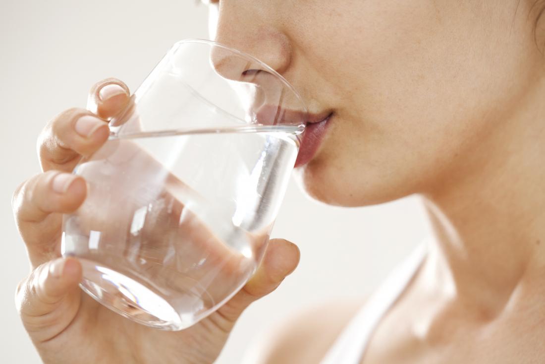 mulher beber água de um copo