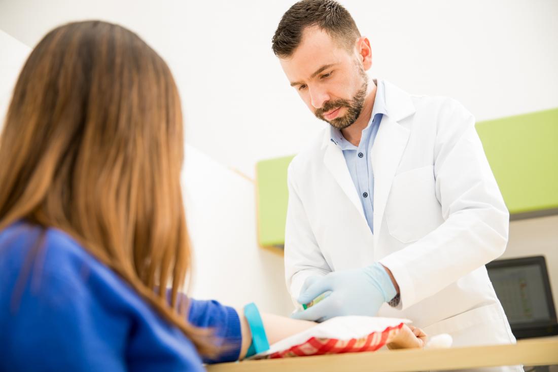 Medico che preleva un campione di sangue di paterni per un test Rast
