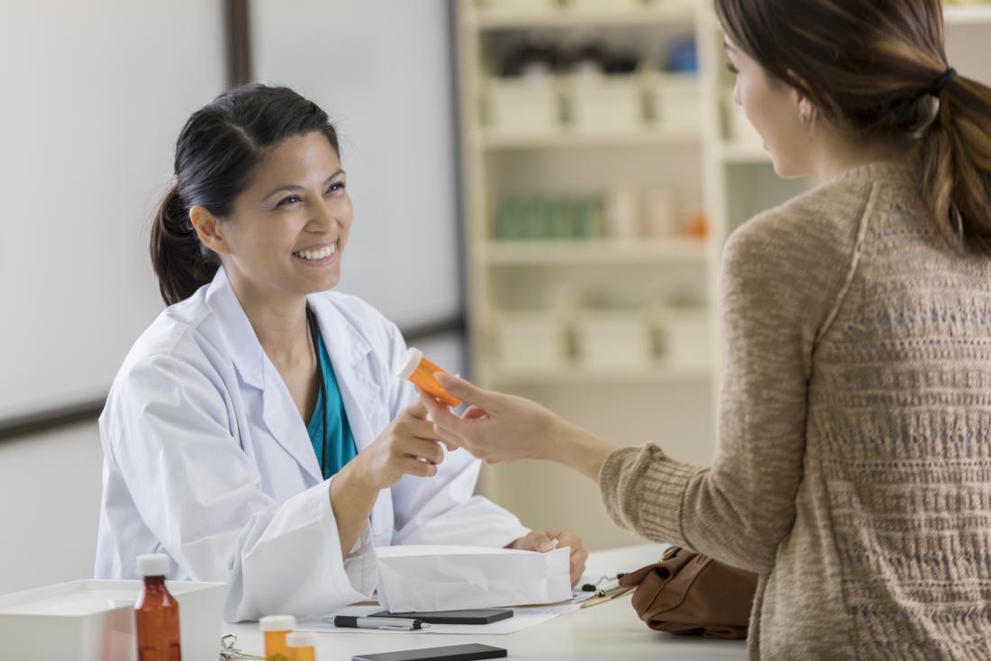Mulher recebendo prescrição de medicação do farmacêutico.