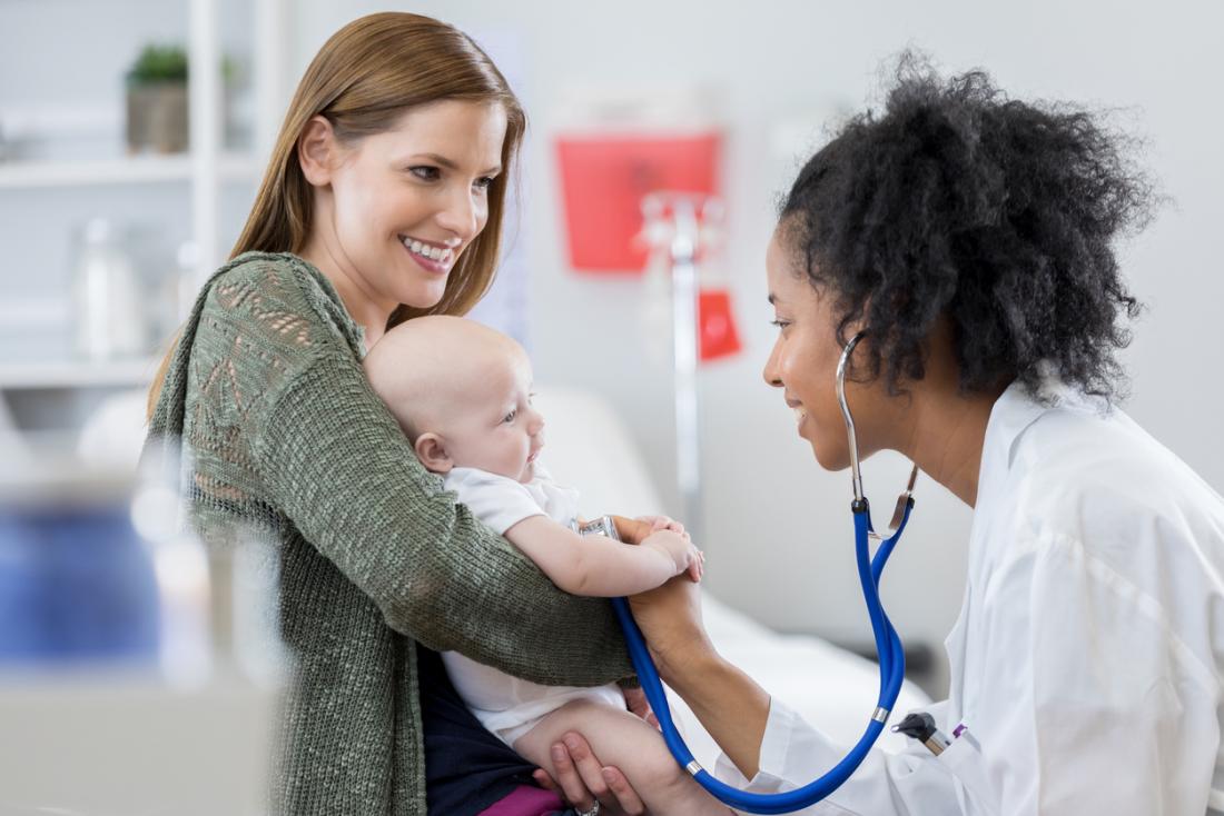 Pediatra escuta bebês respirando e batimentos cardíacos usando um estetoscópio.