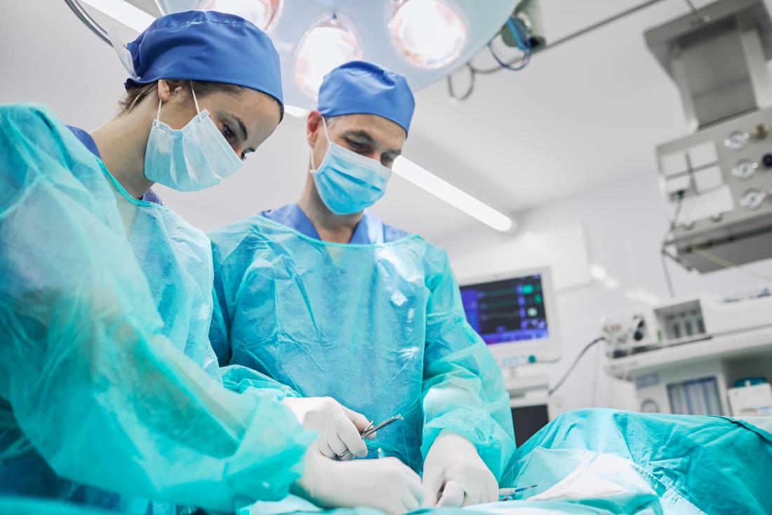 Cirurgiões na sala de cirurgia prestes a realizar colecistectomia laparoscópica.