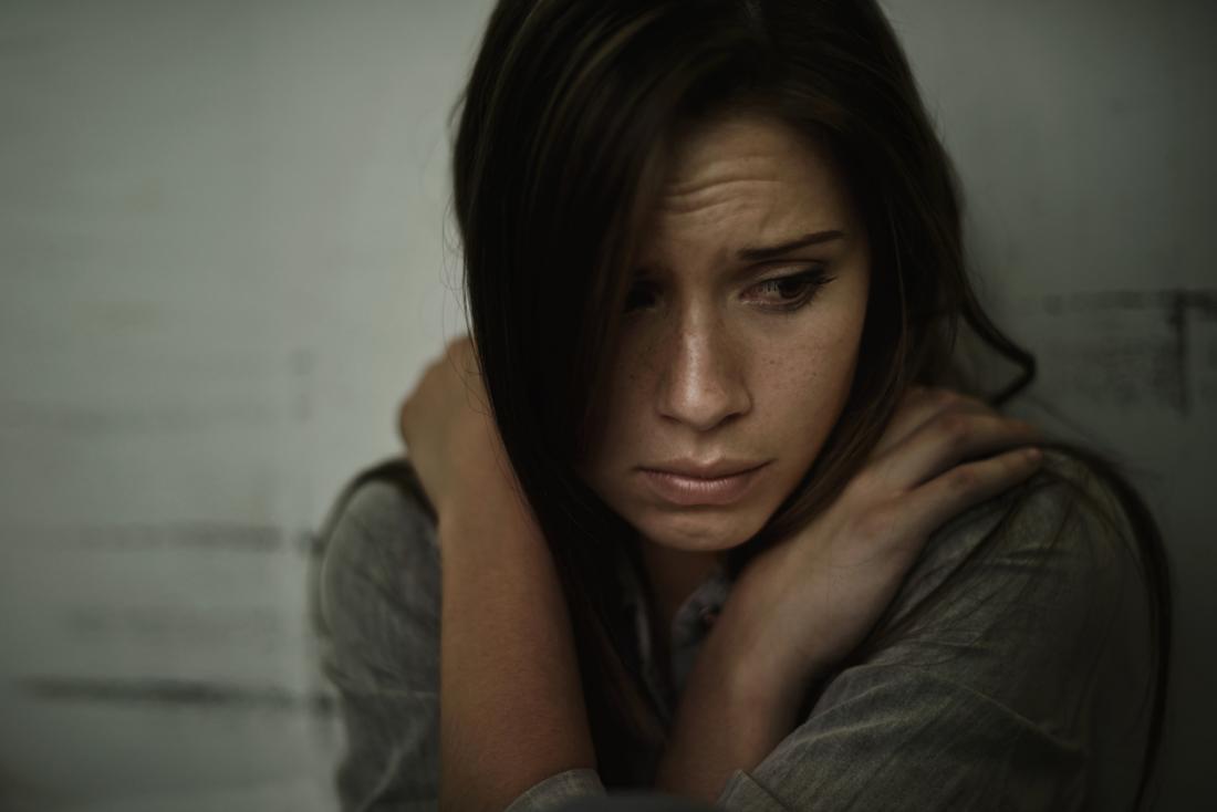 Une femme stressée, anxieuse et déprimée tient ses mains sur sa poitrine.