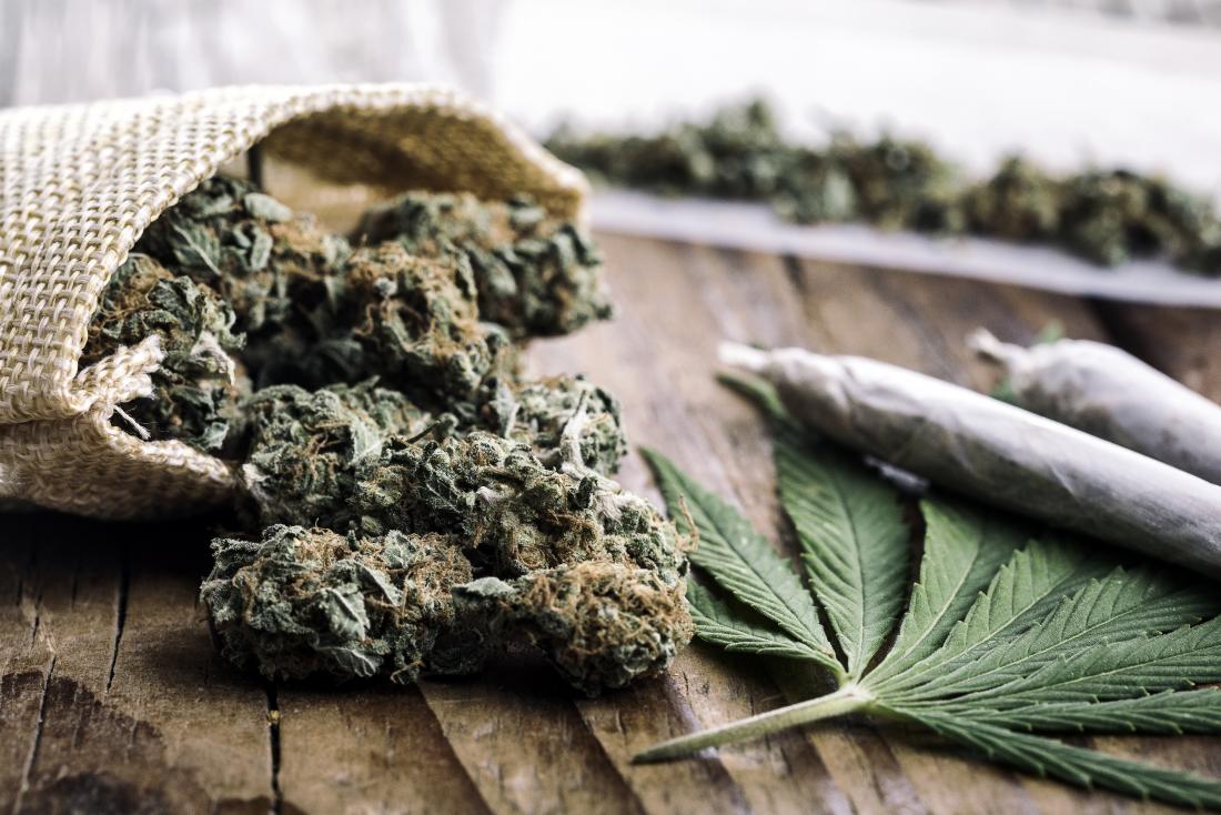 Bourgeons de marijuana, les joints et les feuilles sur une table en bois pour représenter l'allergie à la marijuana.