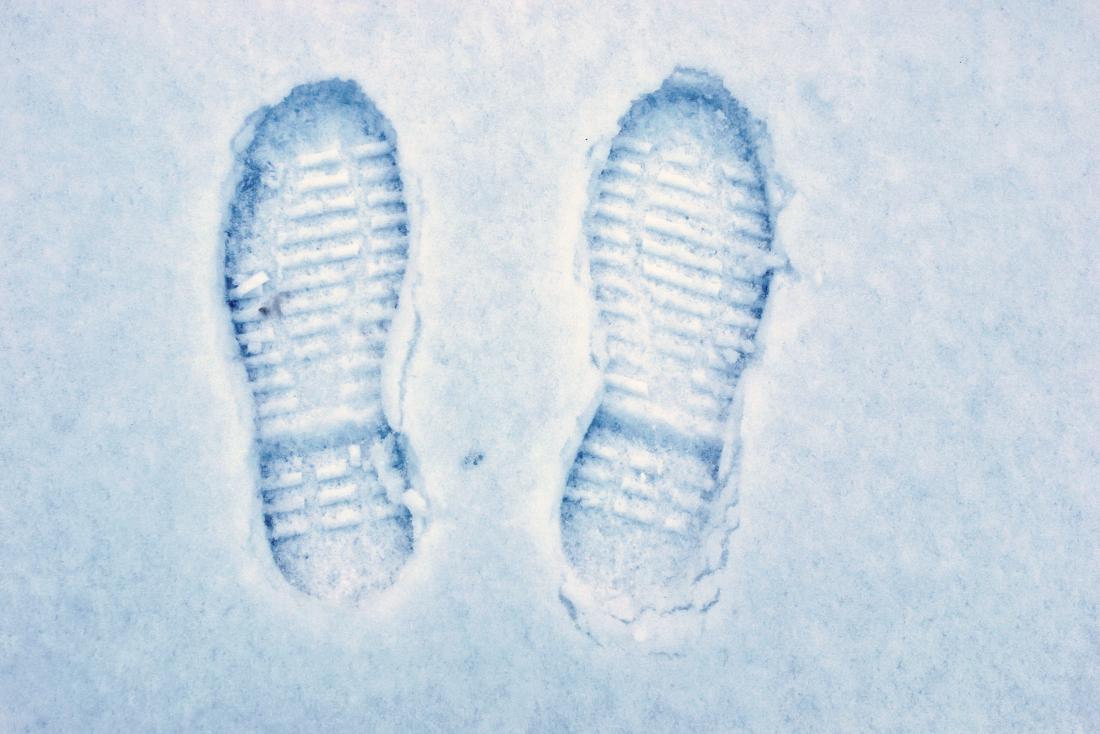 impronta di piedi freddi nella suola delle scarpe nella neve