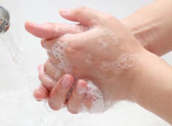 Zwei Hände werden unter dem Wasserhahn gewaschen.