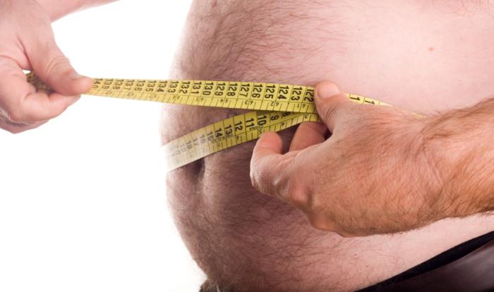 übergewichtiger Mann, der Taille misst