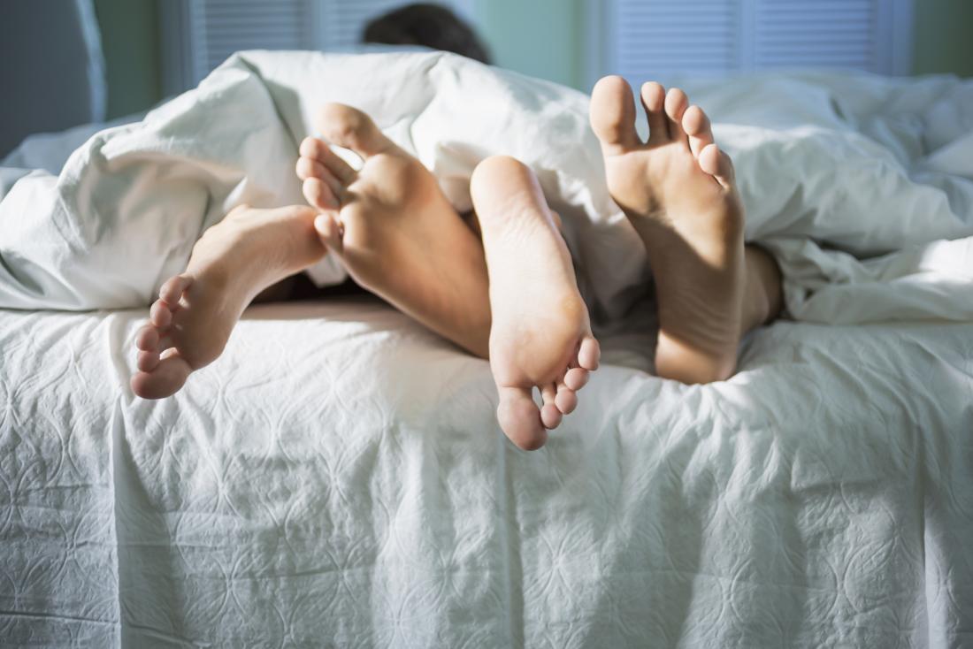 Leute im Bett angesehen von den Füßen