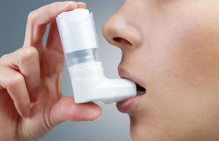 Една жена използва инхалатор за астма