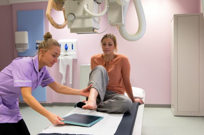 Un'infermiera prepara una radiografia per un piede destro da donna