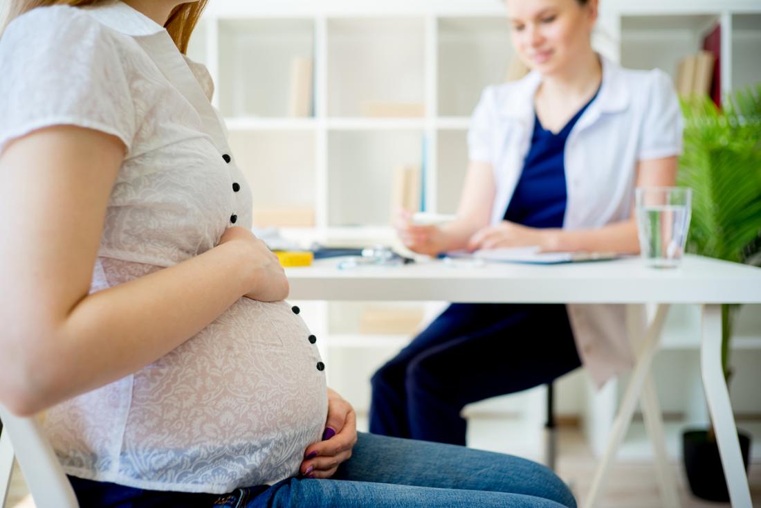 Donna incinta nell'ufficio di medici.