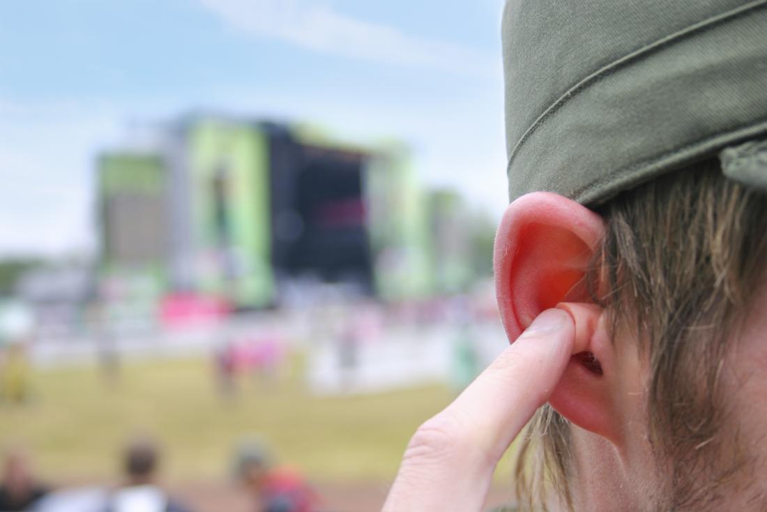 човек на музикалния фестивал, използващ слушалки