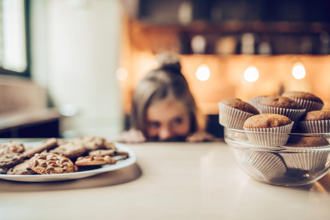 Bambino in una cucina guardando i biscotti