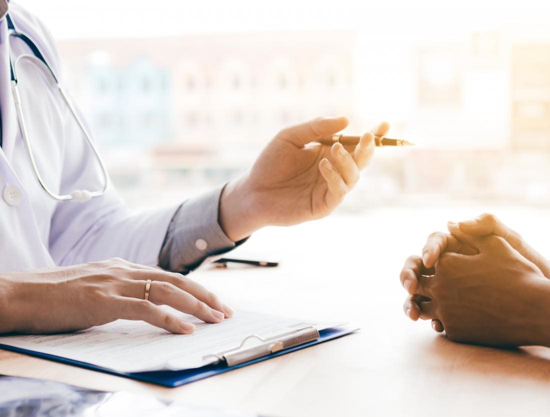 médecin parlant avec le patient au sujet des étiquettes de peau anale