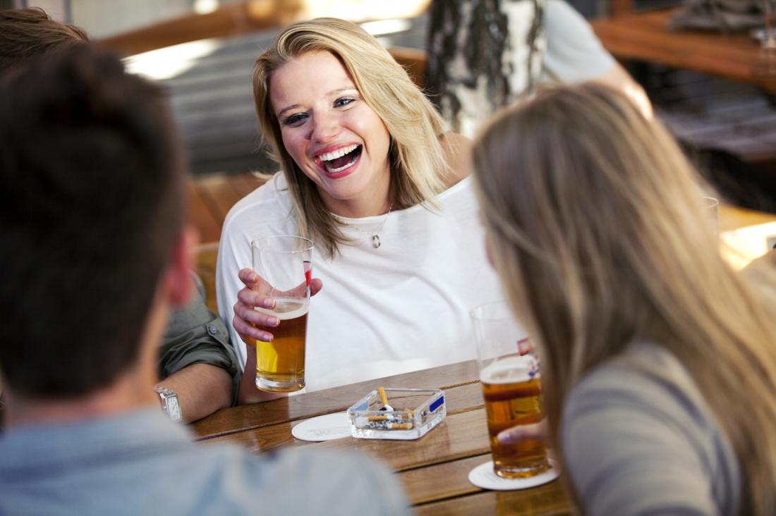 femme buvant et fumant avec des amis