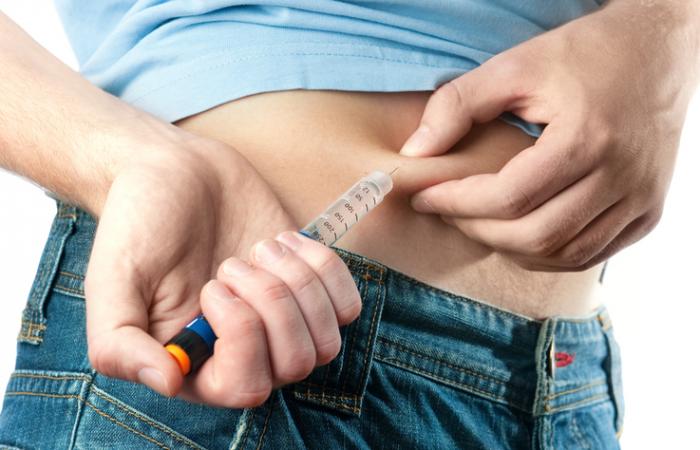 [Nahaufnahme einer Person, die Insulin in ihre Hüfte spritzt]