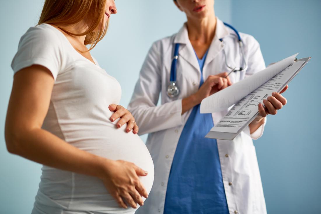 [Une femme enceinte parle avec un médecin]