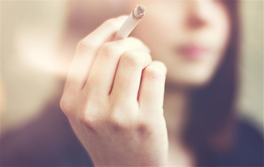 người phụ nữ cầm một điếu thuốc