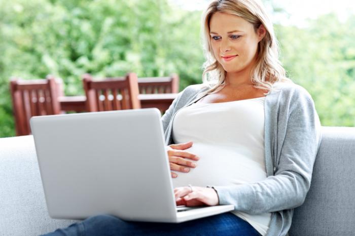 [Eine schwangere Frau mit einem Computer]
