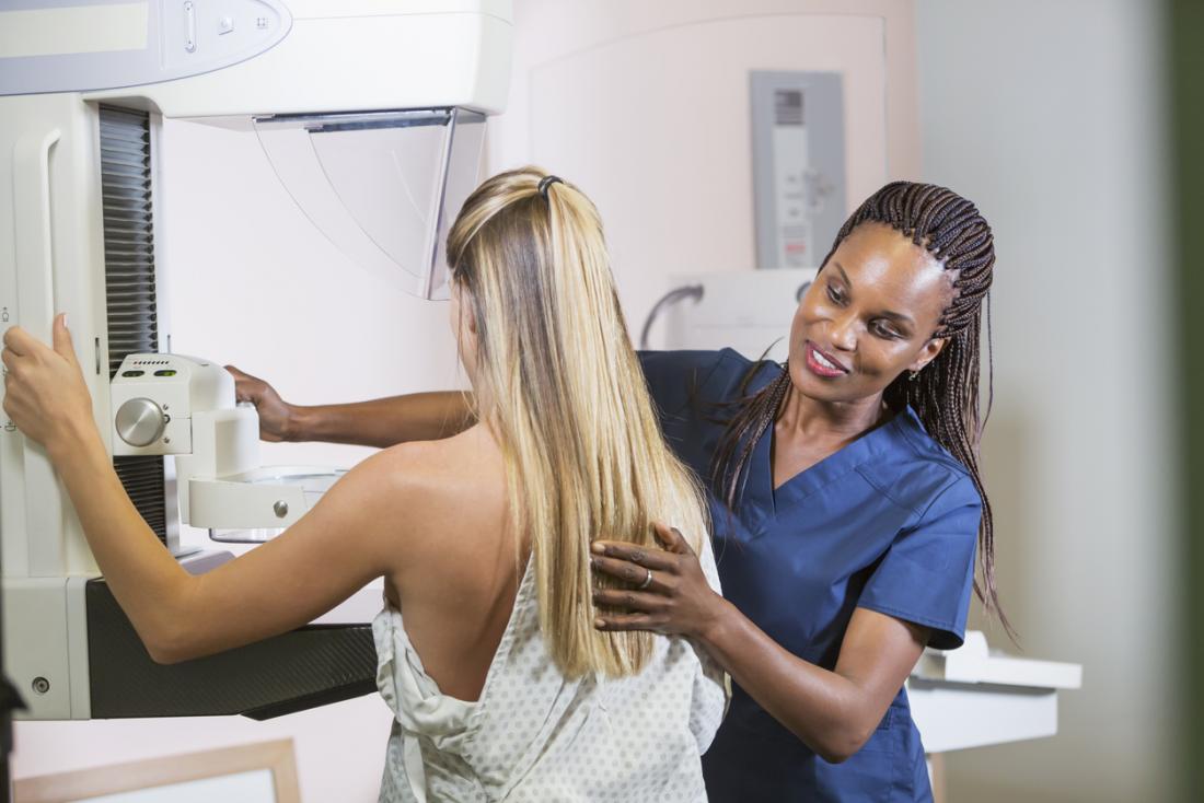 Сестра помага на жената да има мамография.