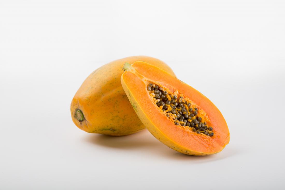 Fruto da papaia cortado ao meio com as sementes que mostram.