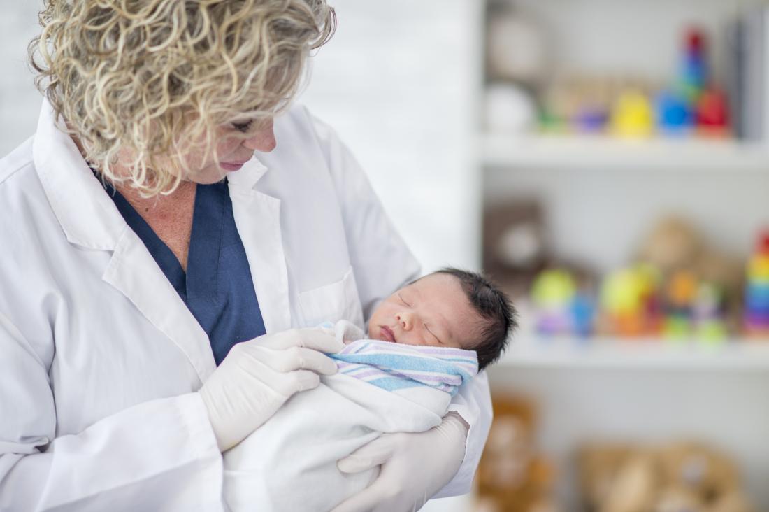 Ein Arzt untersucht ein Neugeborenes auf Nabelschnurgranulom während der regelmäßigen Untersuchungen.