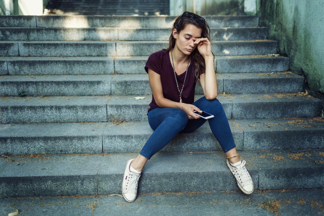 Mädchen saß auf Stufen, die traurig mit leichter Depression aussehen