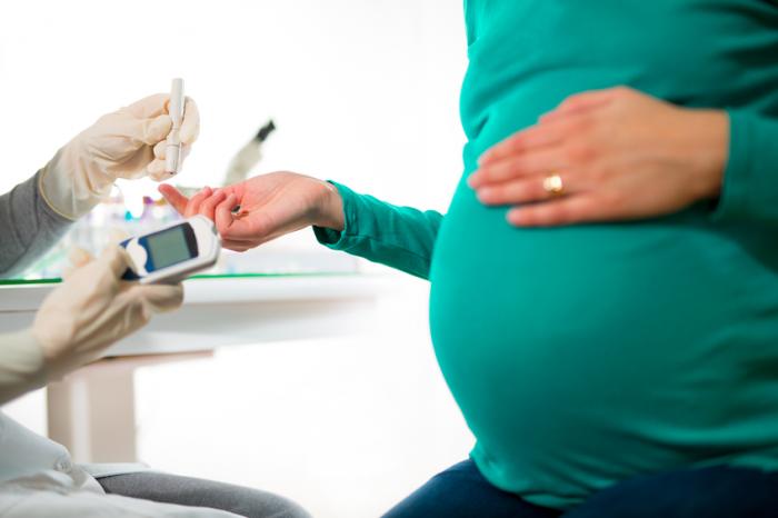 Eine schwangere Frau hat ihren Blutzucker gemessen.