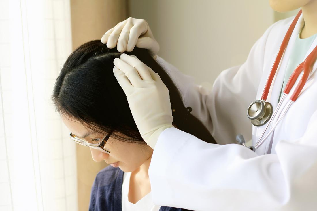 Doktor, der die Kopfhaut eines Patienten auf verdächtiges Ekzem auf Kopfhaut überprüft