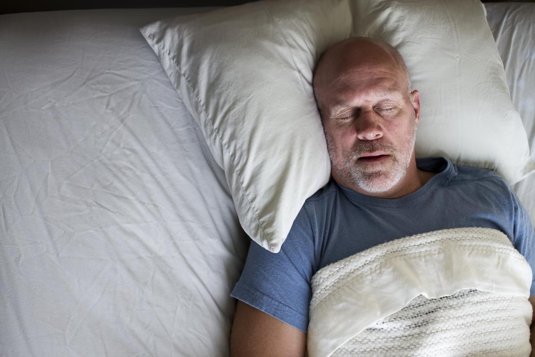 Mann mittleren Alters schlafend im Bett