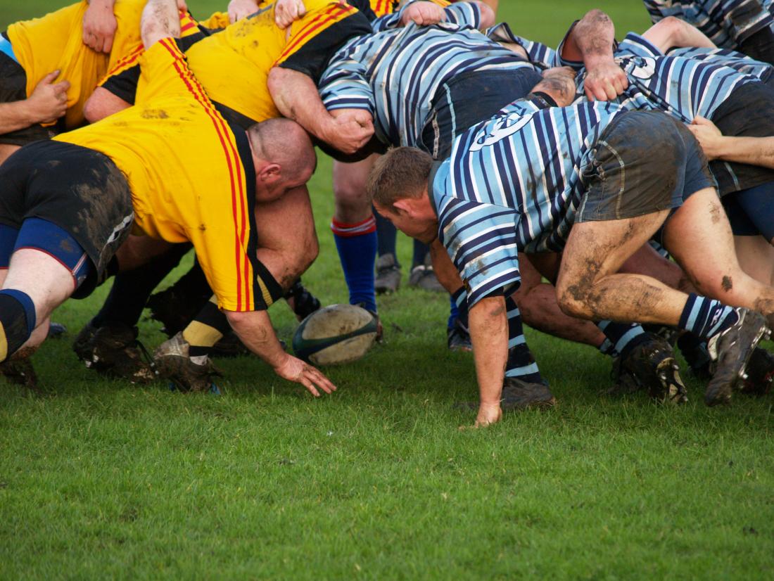 Männer, die Rugby spielen, die vom Zeichen des Kampfes gefährdet werden können