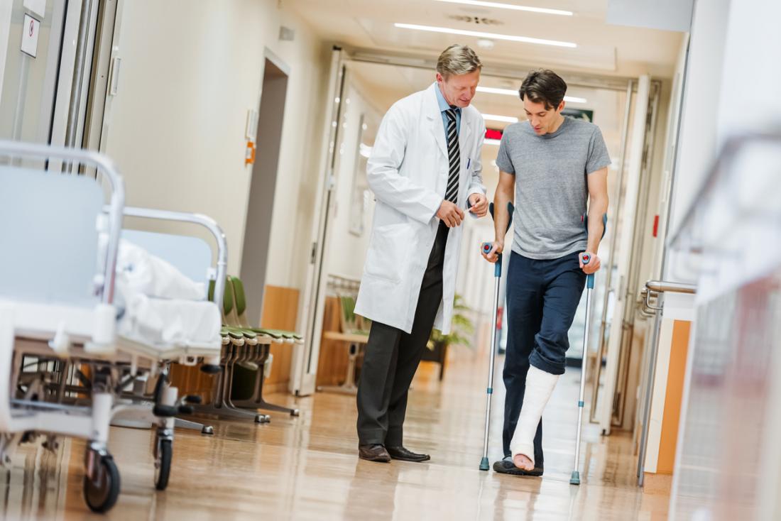 Patient avec une jambe cassée avec des béquilles, avec un médecin à l'hôpital.