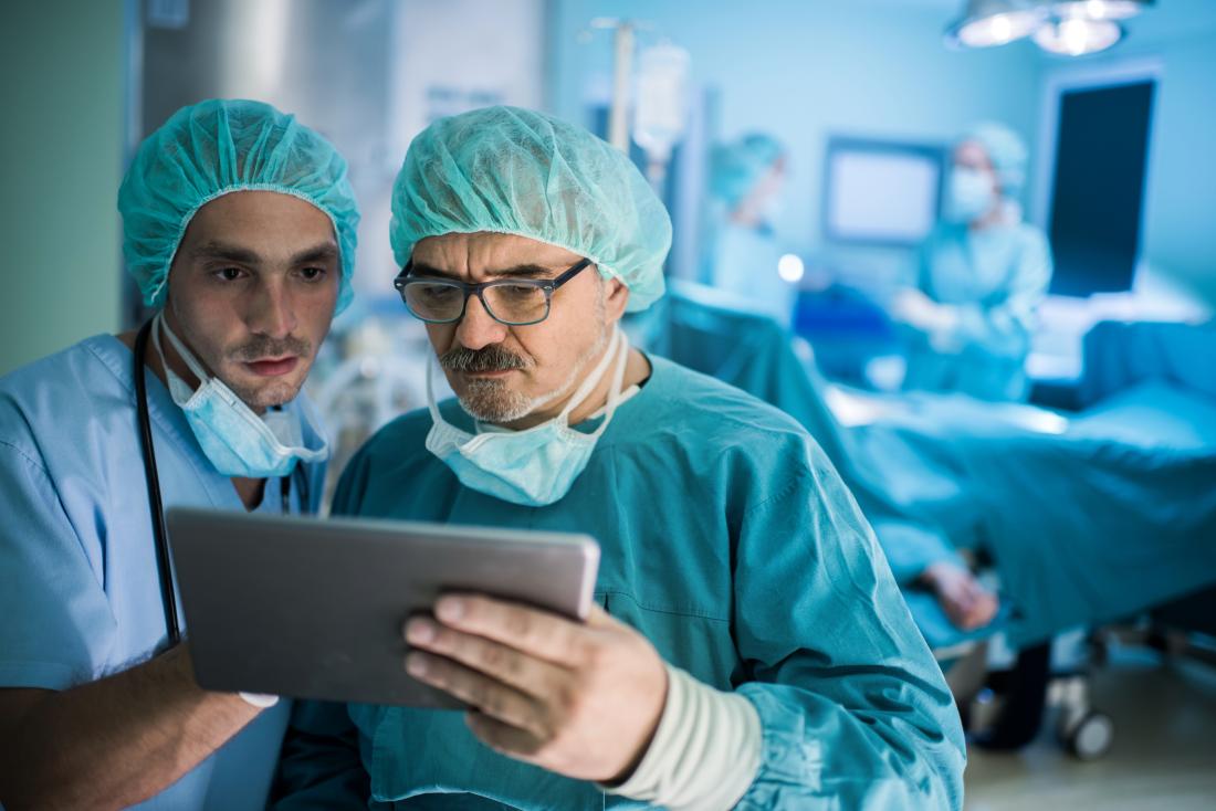 Chirurgiens regardant palmtop dans la salle d'opération.