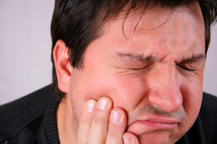 Ein Mann erlebt starke Schmerzen im Mund.