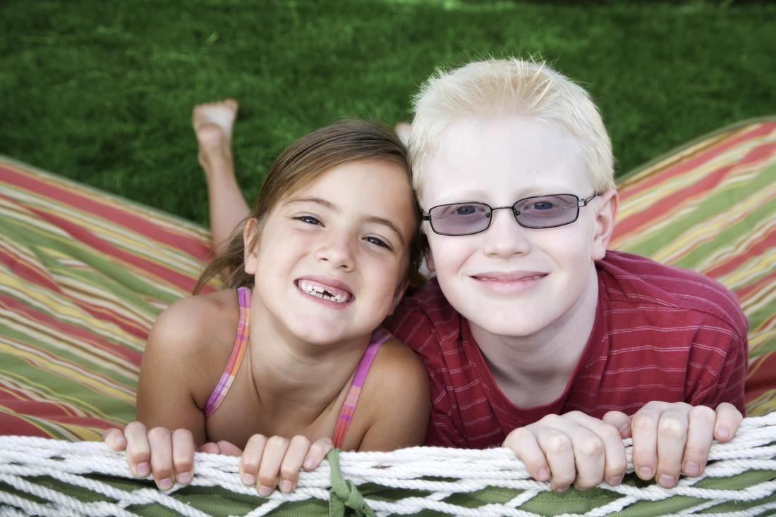 Jeune garçon avec albinisme, à côté de la jeune fille sans.