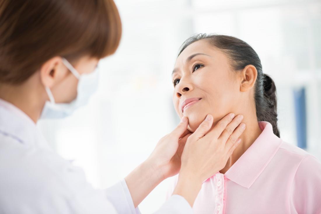 Доктор, проверяващ пациентите за шията и гърлото за нарушение на щитовидната жлеза.