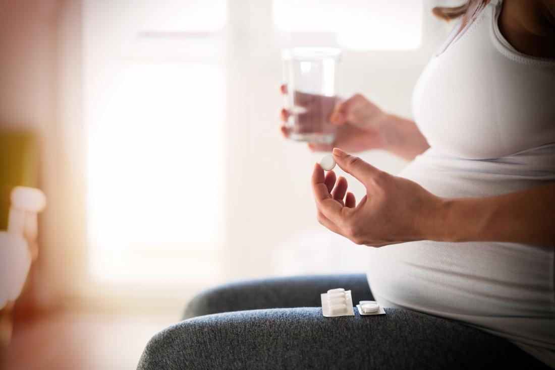 Бременна жена, която приема мулти-витамини