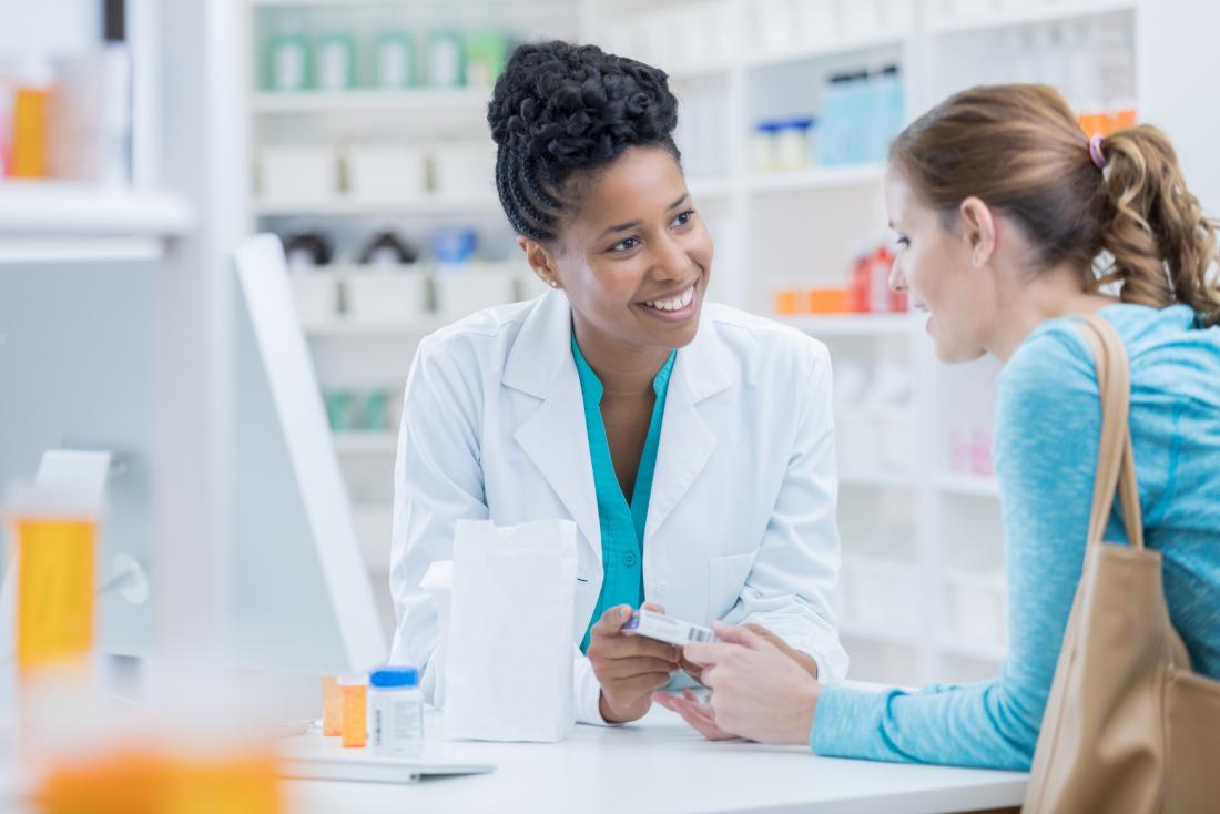 Farmacêutico discutindo diferentes medicamentos com o paciente.