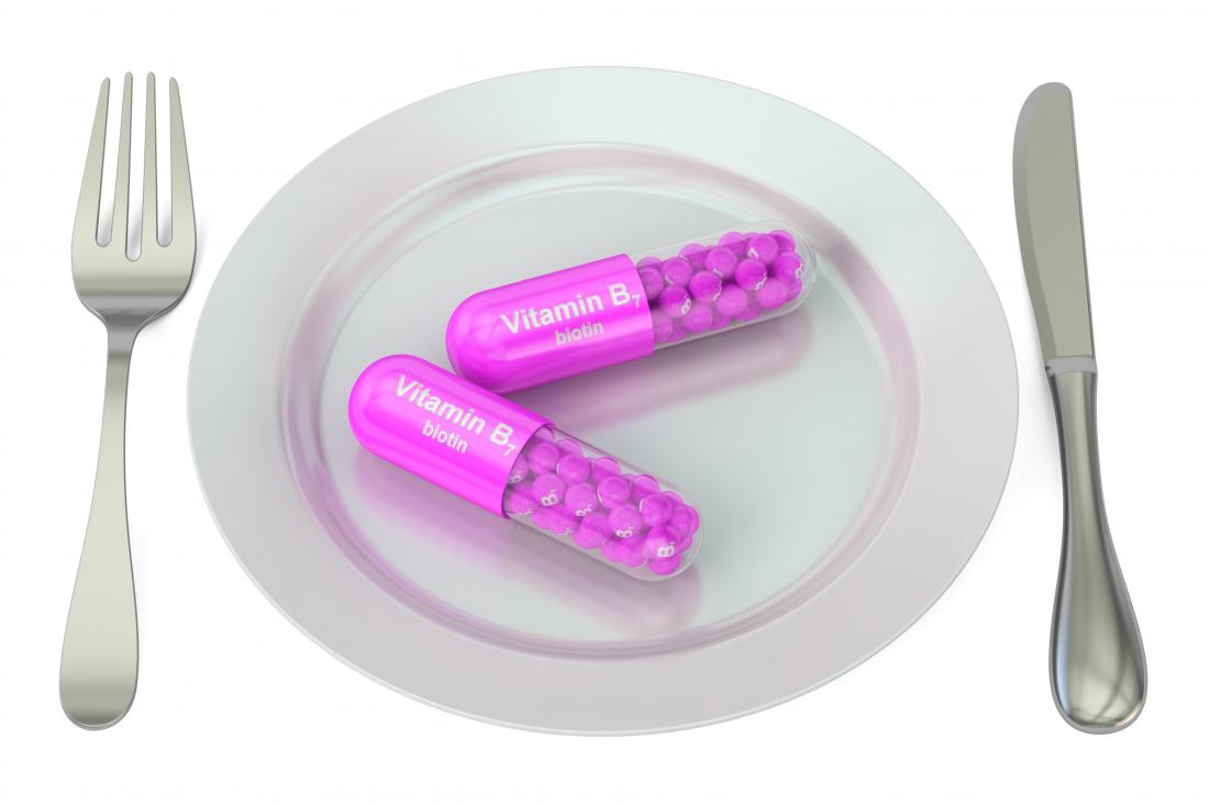 capsula vitamina B7 su un piatto con coltello e forchetta
