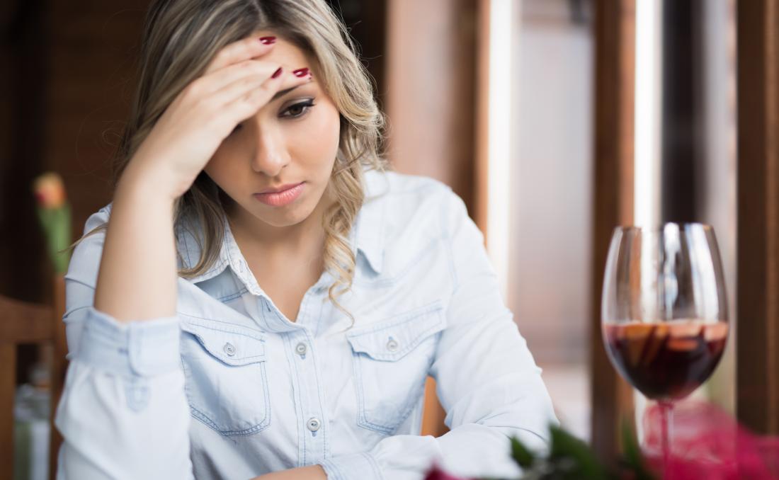 Donna che sembra triste vicino al vino