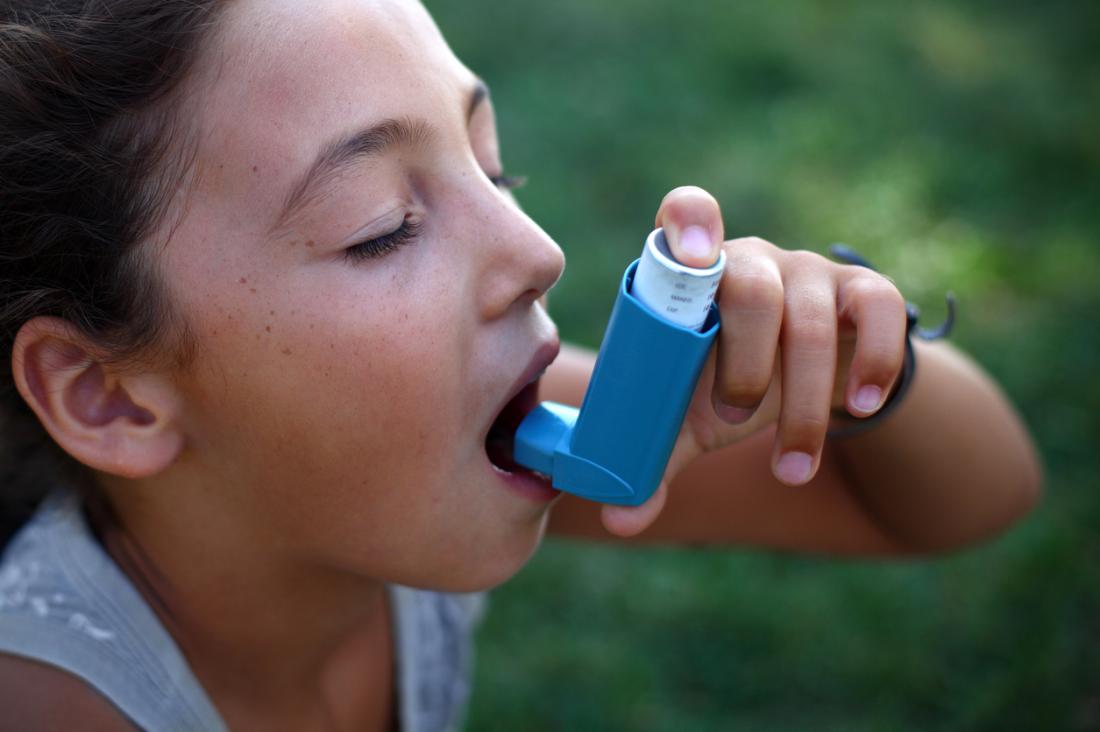 jovem garota usando um inalador para asma
