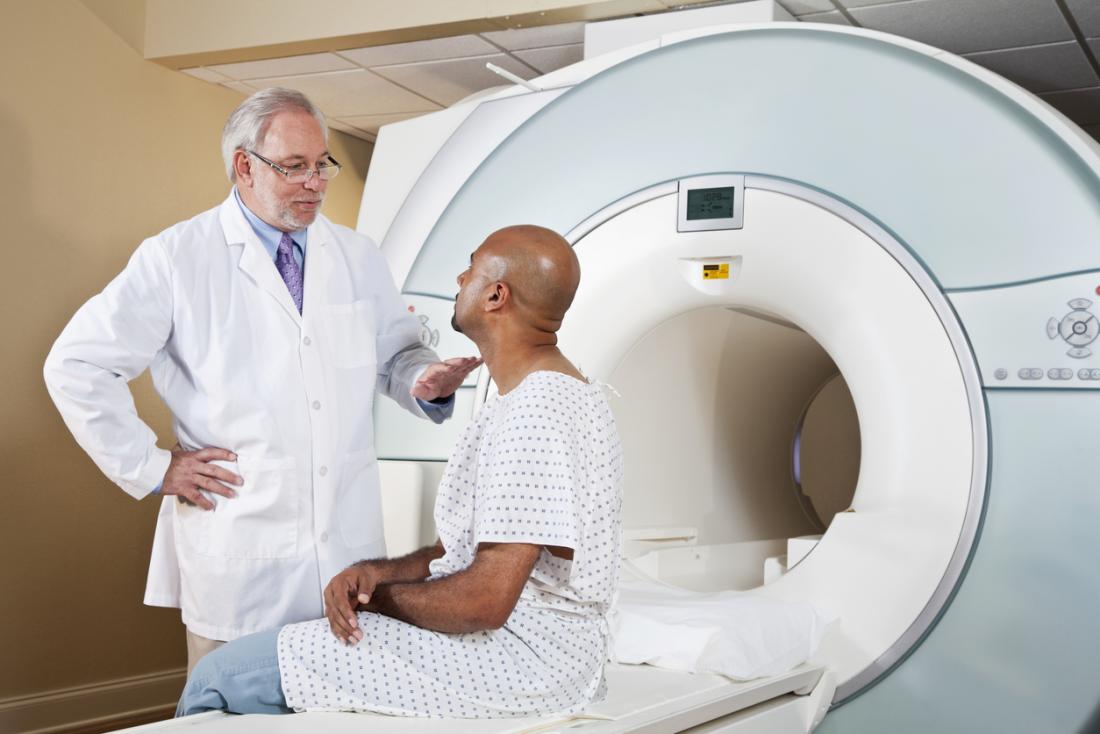 医者は、MRIスキャンを受ける予定のMRIマシンで患者と話しています。