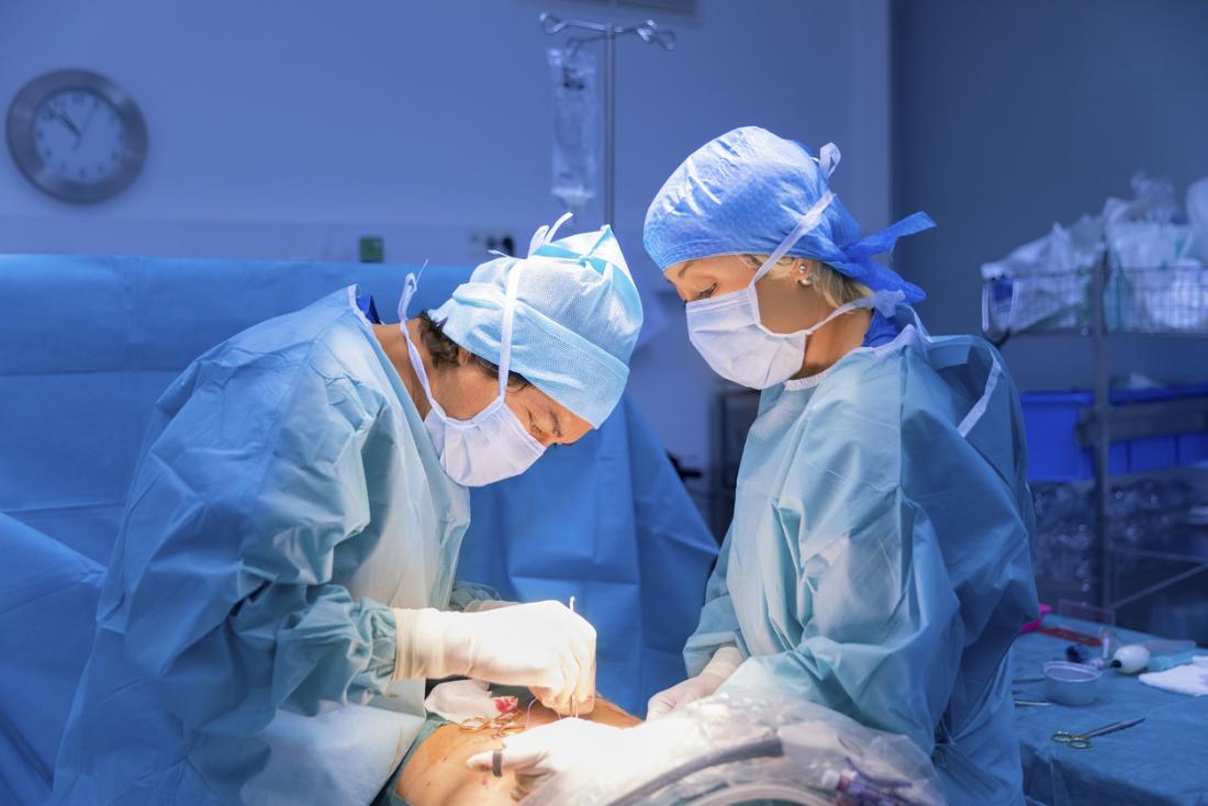 Хирурзи в оперативния театър, изпълняващи операция на пациент.