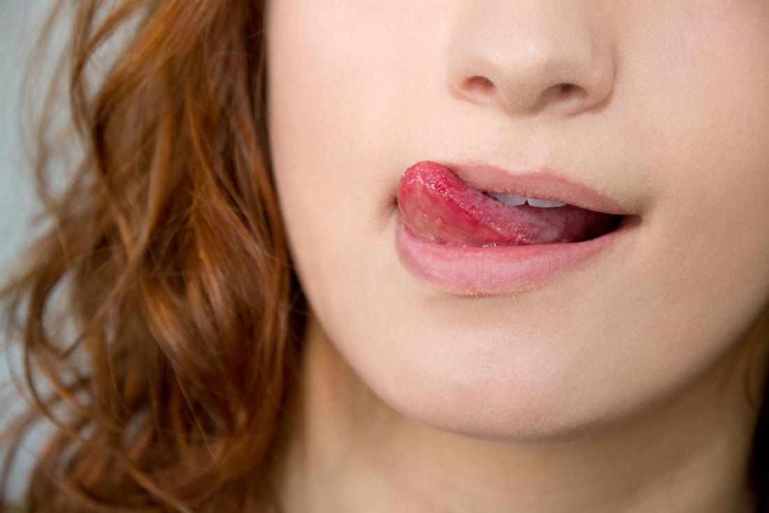 女性は口の中の苦い味のために唇を舐める