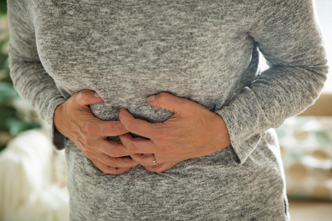 可能な胃の痙攣を伴う胃を保持する女性