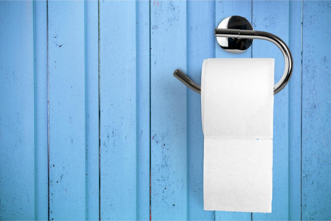 Papier toilette sur le support sur le mur bleu représentant le sang lors de l'essuyage