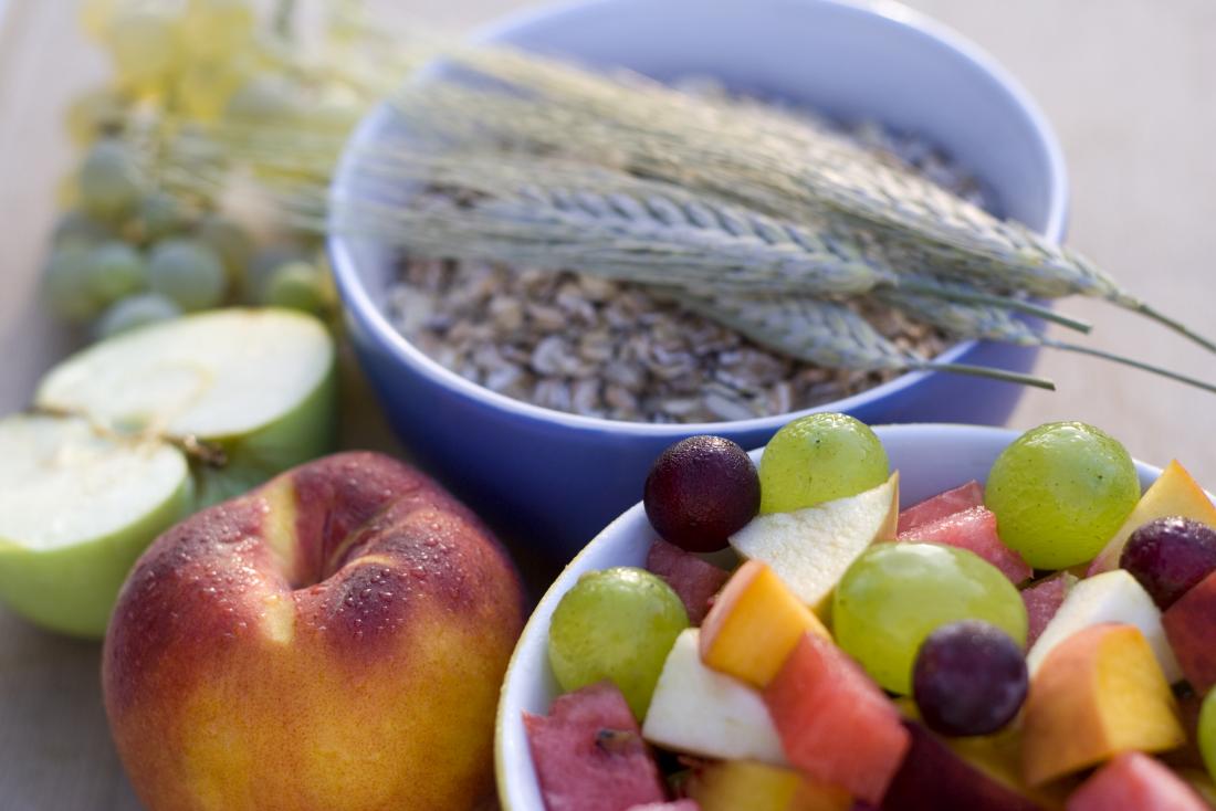 Alimenti ricchi di fibre tra cui avena e frutta.