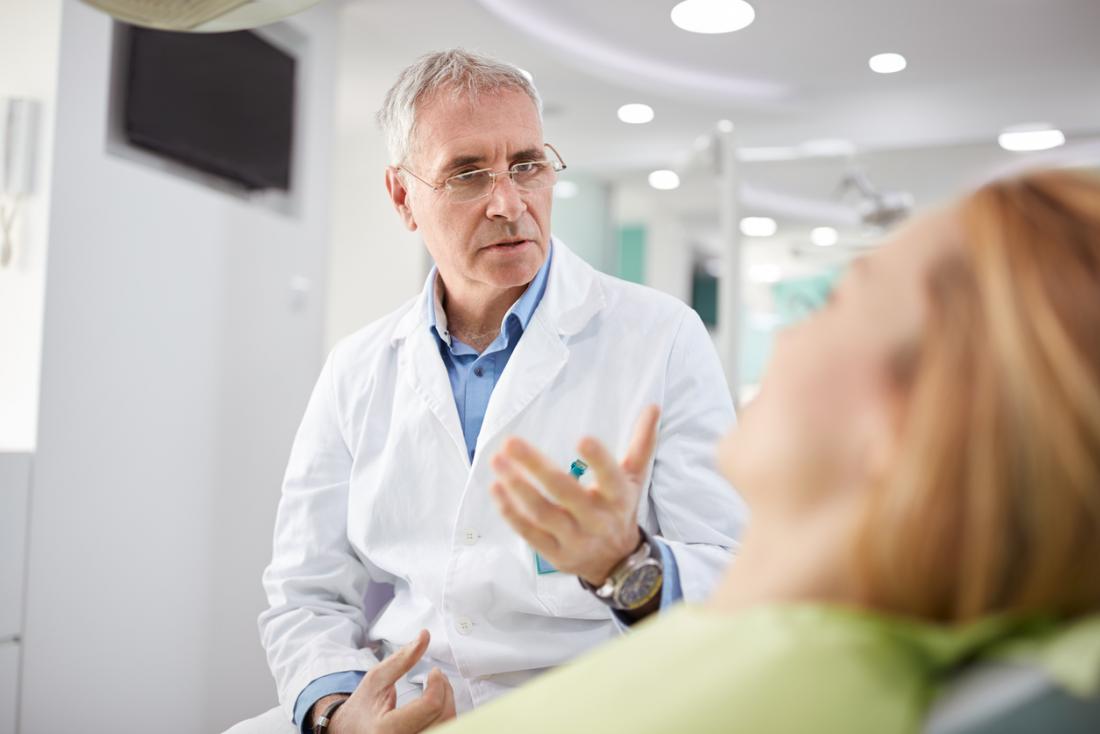 Cirurgião-dentista falando com o paciente.