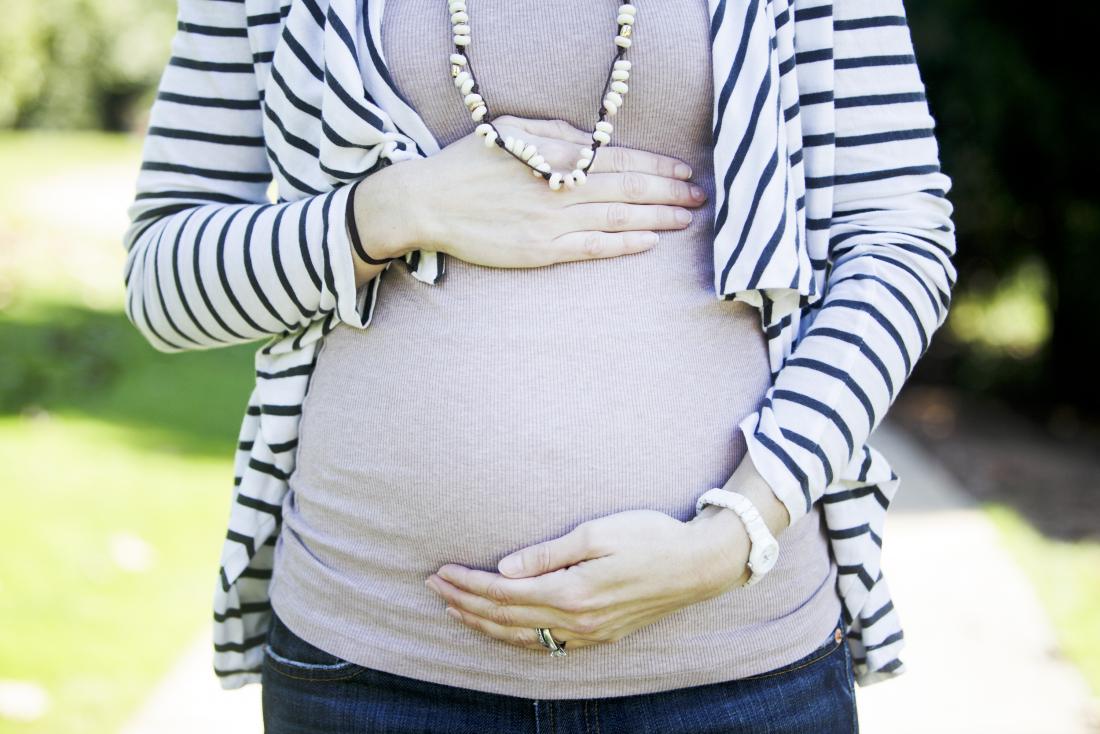 бременната жена държи корема