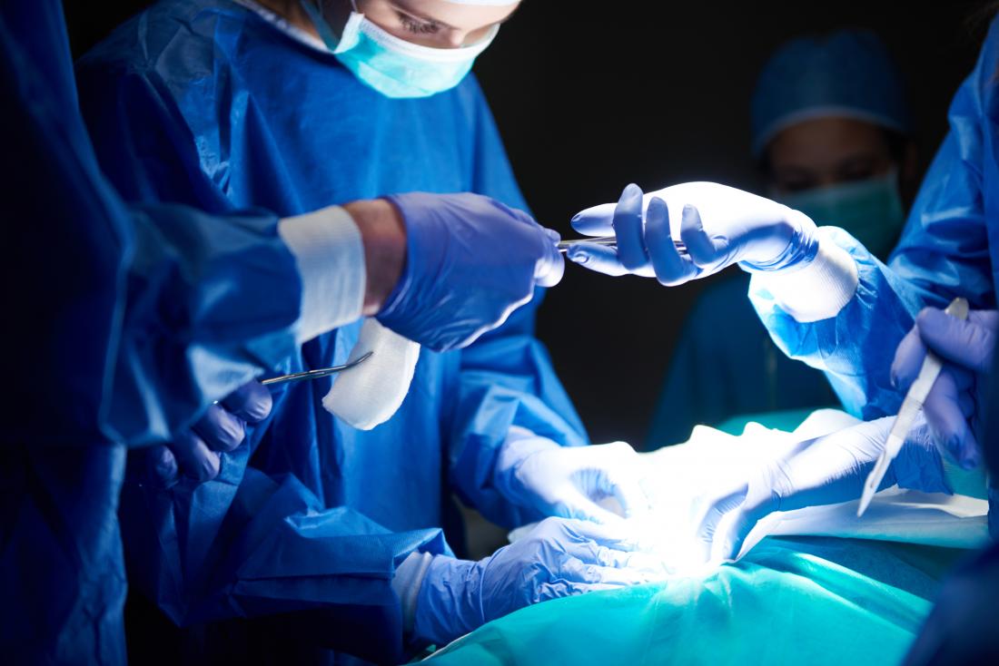Chirurgiens travaillant dans le théâtre d'opération sombre